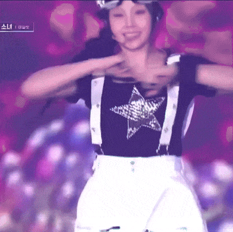 a woman in a black shirt with a star on it is dancing on a stage .