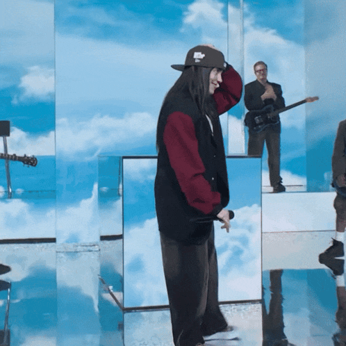 a man playing a guitar and another man playing a guitar are reflected in a mirror