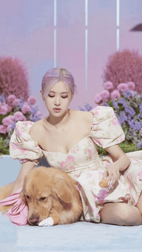 a woman in a floral dress is laying on the floor with a dog