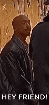 a man in a leather jacket is standing next to another man and says `` hey friend ! ''