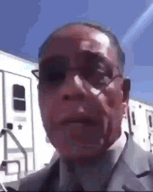 a close up of a man wearing sunglasses and a suit .