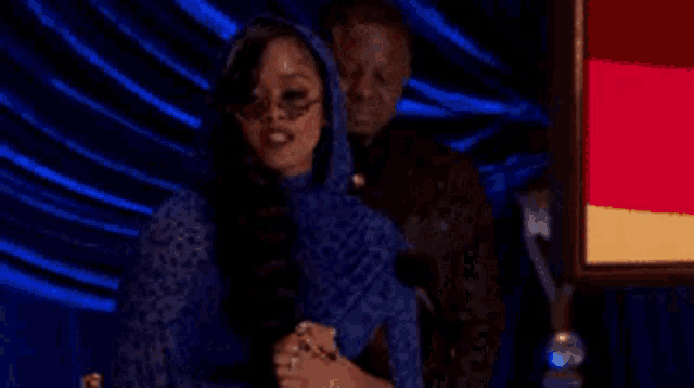 a man and a woman are standing next to each other .