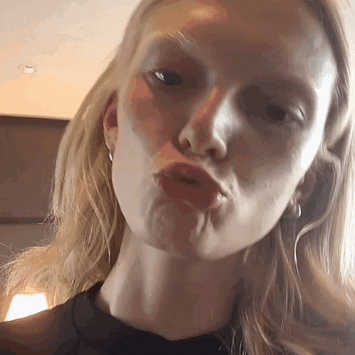 a close up of a woman 's face making a funny face