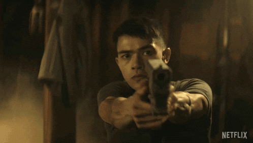a man is pointing a gun at the camera with a netflix logo behind him