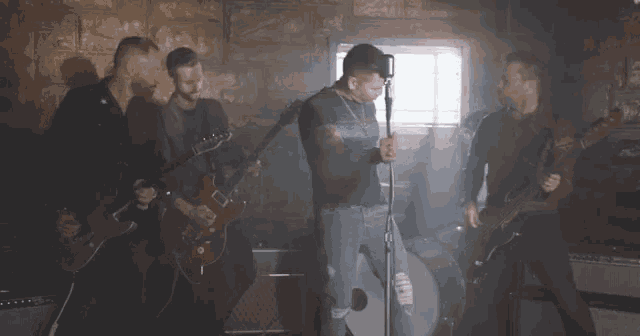 a man singing into a microphone in front of a group of men playing instruments