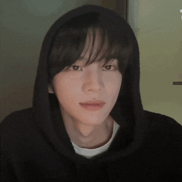 a close up of a young man wearing a black hoodie