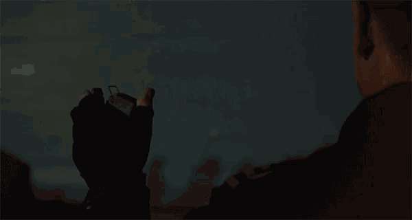 a person is holding a small object in their hand in front of a light