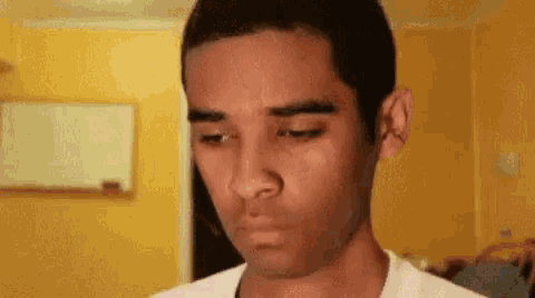 a man is making a funny face with his eyes closed in a room .