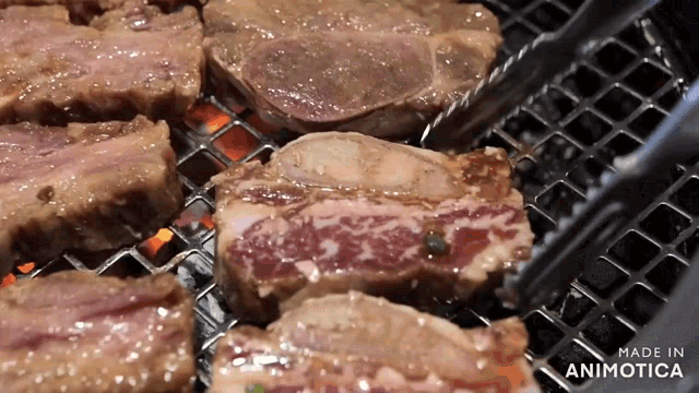 steaks are being cooked on a grill and the words made in animotica are on the bottom right