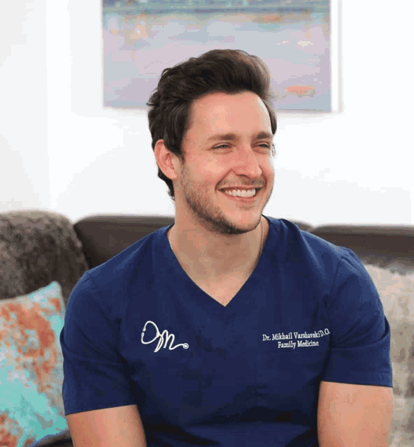 a smiling man wearing a blue shirt that says dr. michael mankowski family medicine