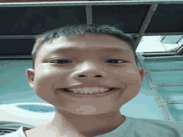 a young boy making a funny face in front of a fan that says deluxe