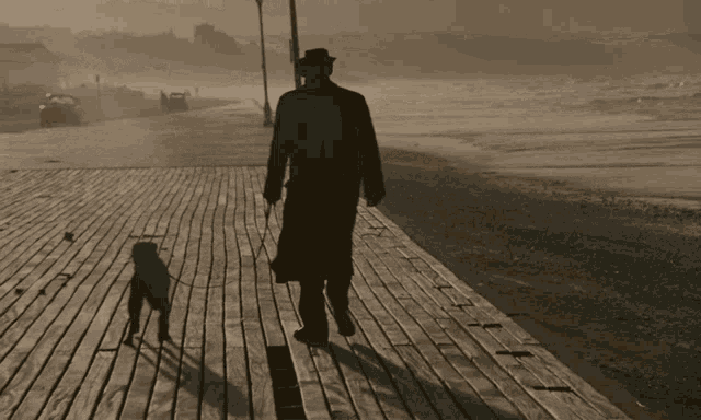a man walking a dog on a boardwalk near the beach