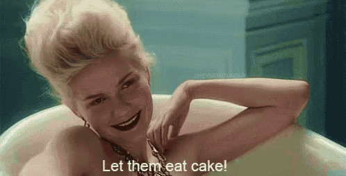 a woman is laying in a bathtub with the words `` let them eat cake '' written on the screen .
