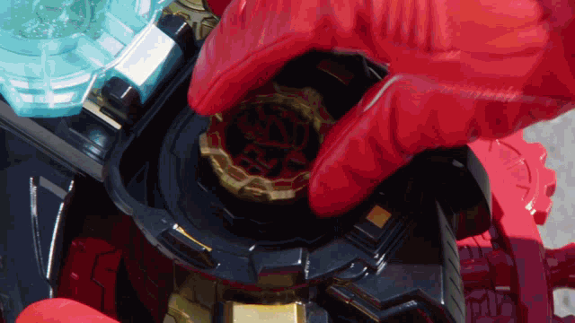 a person in a red glove is holding a gold object with the letter r on it