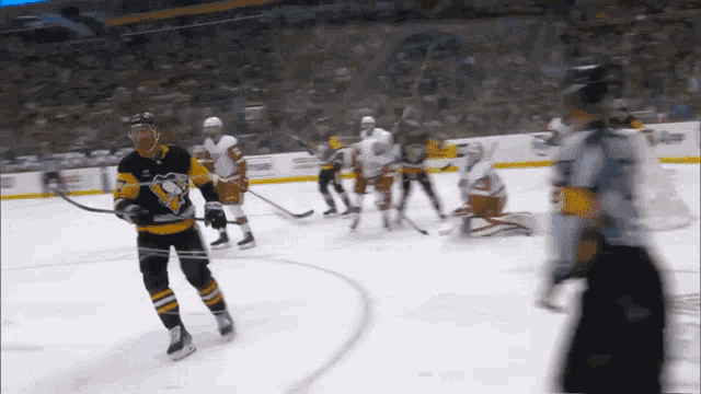 a hockey player in a pittsburgh penguins jersey is holding a hockey stick