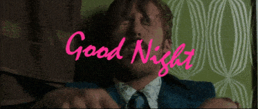 a man in a suit and tie laying on a bed with the words good night written in pink