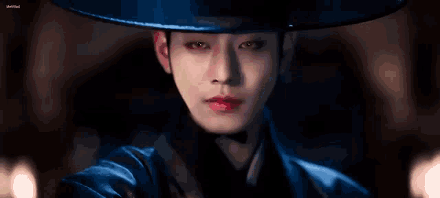 a close up of a person wearing a hat and a blue costume .