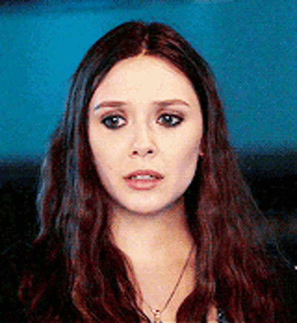 a close up of a woman 's face wearing a necklace