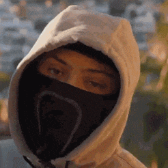 a close up of a person wearing a hoodie and a mask .