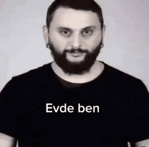 a man with a beard is wearing a black t-shirt with the words evde ben on it .