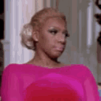 a woman in a pink dress is making a funny face while sitting in front of a window .