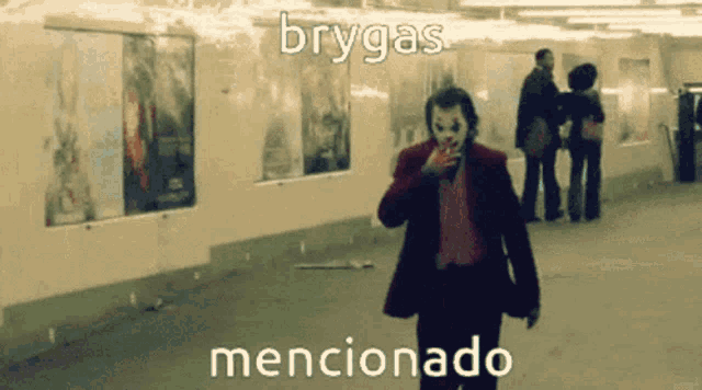 a man in a joker costume is smoking a cigarette in a subway station