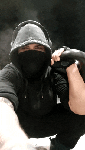 a man wearing a black hoodie and headphones takes a selfie