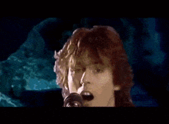 a woman is singing into a microphone in front of a drum set that says mk eddie .
