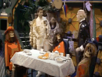 a group of people are standing around a table with a white tablecloth