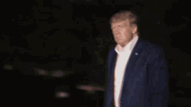 a blurry picture of a man in a suit and tie giving the middle finger
