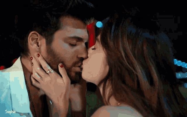 a man and a woman are kissing with the word sophie visible in the corner