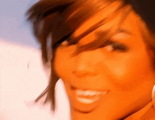 a close up of a woman 's face with her hair blowing in the wind .