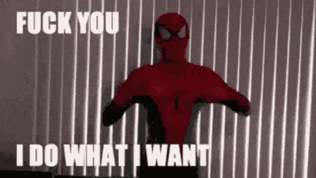a man in a spiderman costume is standing in front of a wall with the words " fuck you i do what i want "