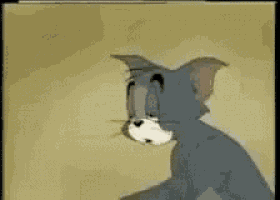 a cartoon of tom from tom and jerry is sitting on a table .