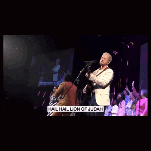 a man singing into a microphone with the words " hail hail lion of judah " on the bottom