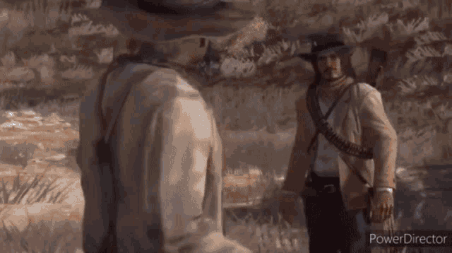 two men in cowboy hats are standing next to each other in the grass .