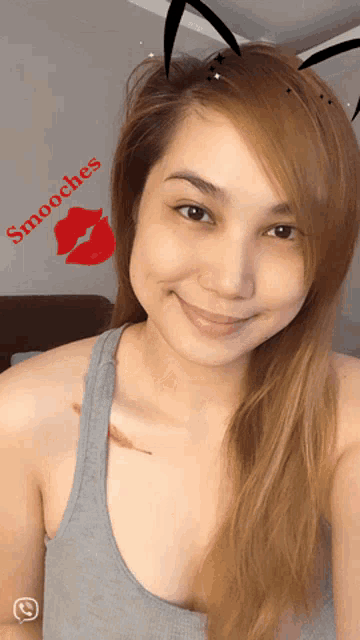 a woman wearing bunny ears and a tank top with smooches written on the bottom