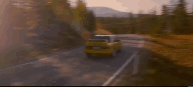 a yellow car is driving down a road next to a sign that says k.