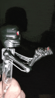 a person is holding a toy robot with red eyes