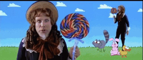 a man in a wig is holding a large lollipop