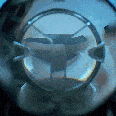 a close up of a circular object with a reflection of a person 's face