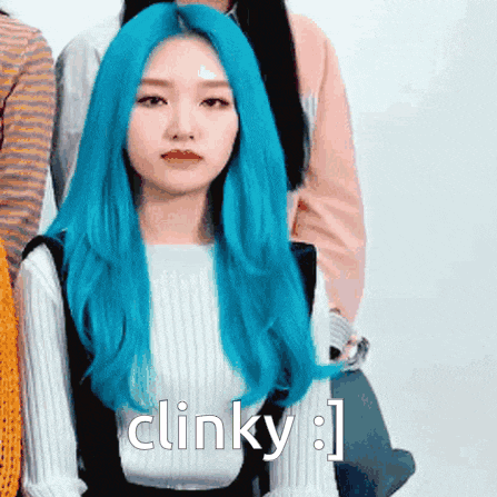 a girl with blue hair is sitting in front of a group of people and says clinky