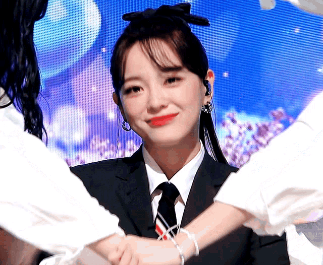 a woman in a suit and tie is smiling