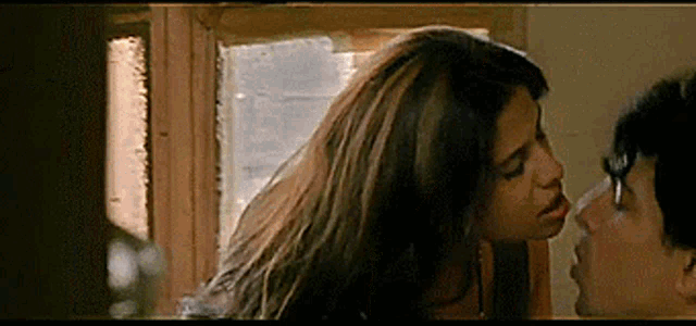 a woman is kissing a man on the nose in a movie scene .