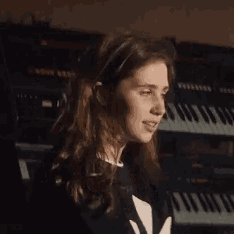 a young woman is standing in front of a keyboard .
