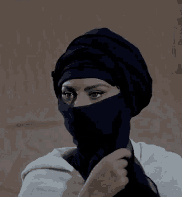 a woman wearing a blue scarf around her face .