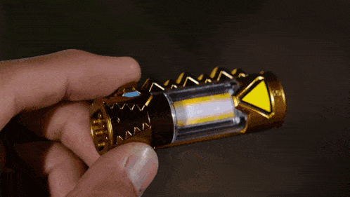 a person is holding a gold object with a light inside
