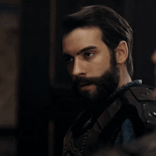 a man with a beard is wearing a black armor