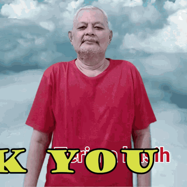 a man in a red shirt is standing in front of a cloudy sky with the words kyouh written in yellow