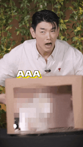 a man in a white shirt is holding a cardboard box that says aaa